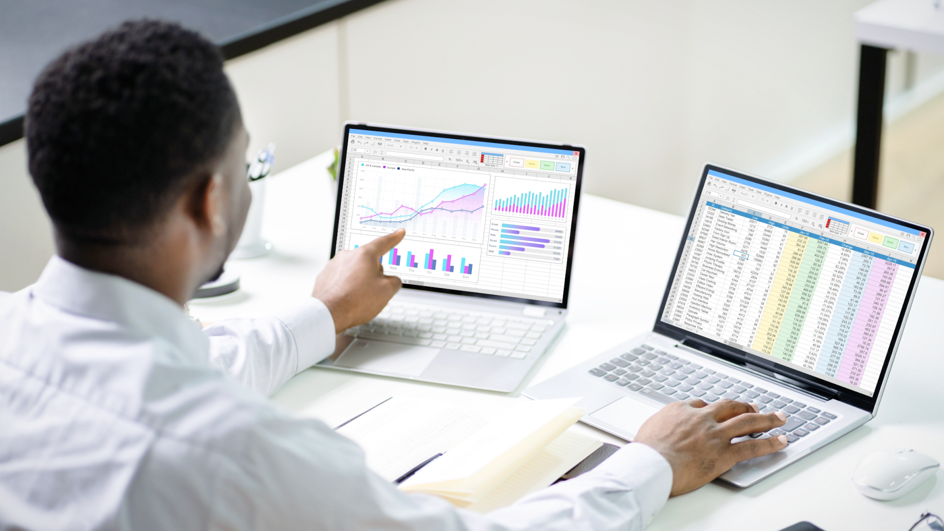 man auditing medical codes on 2 laptops