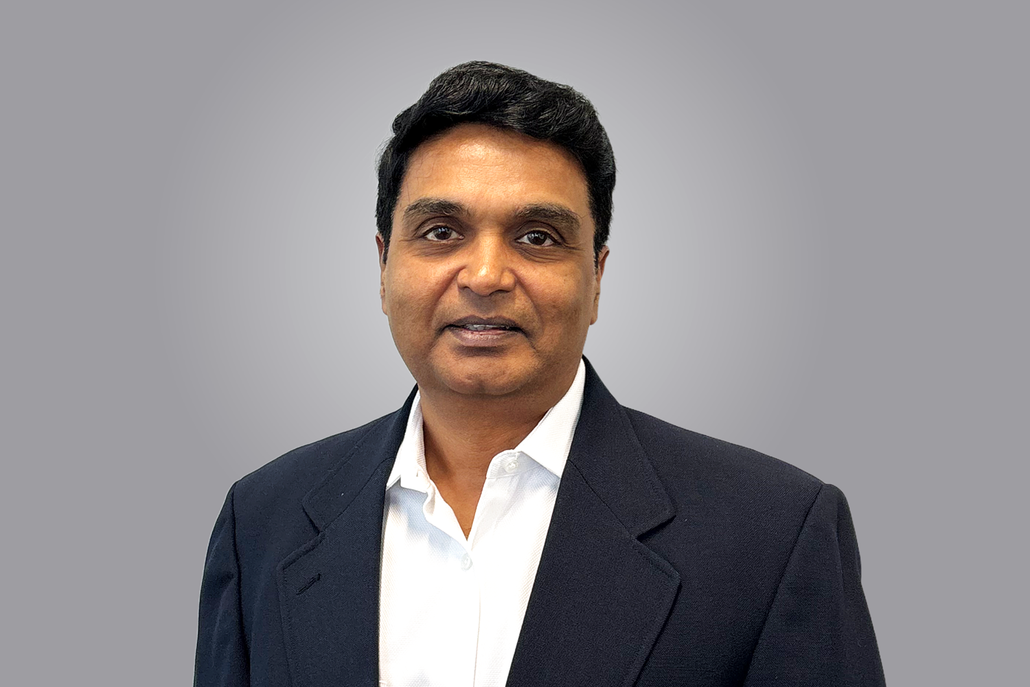 headshot photo of a man in a dark blue suit